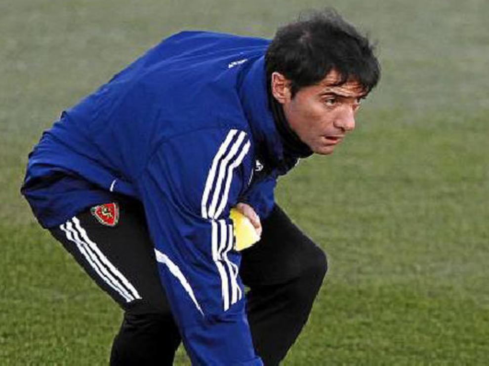Marcelino coloca unas señales de plástico sobre el césped de la Ciudad Deportiva