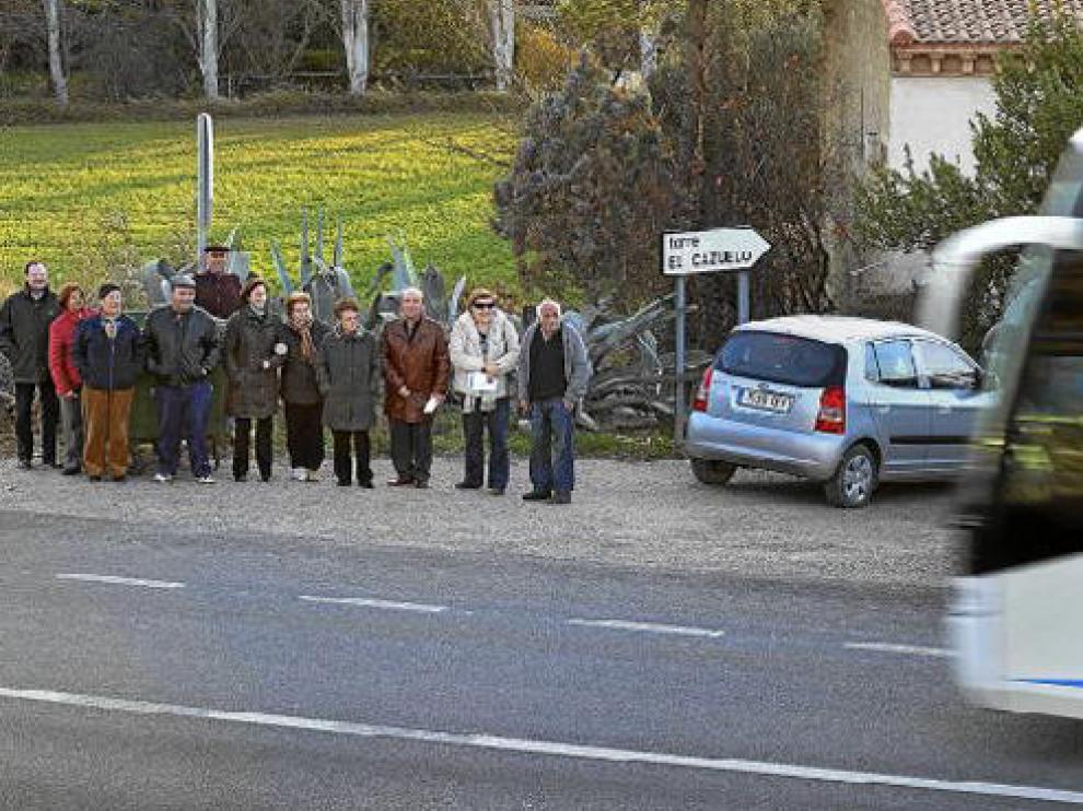 Algunos vecinos del Cazuelo ven pasar el autobús, que desde principios de diciembre ha dejado de parar en la barriada.