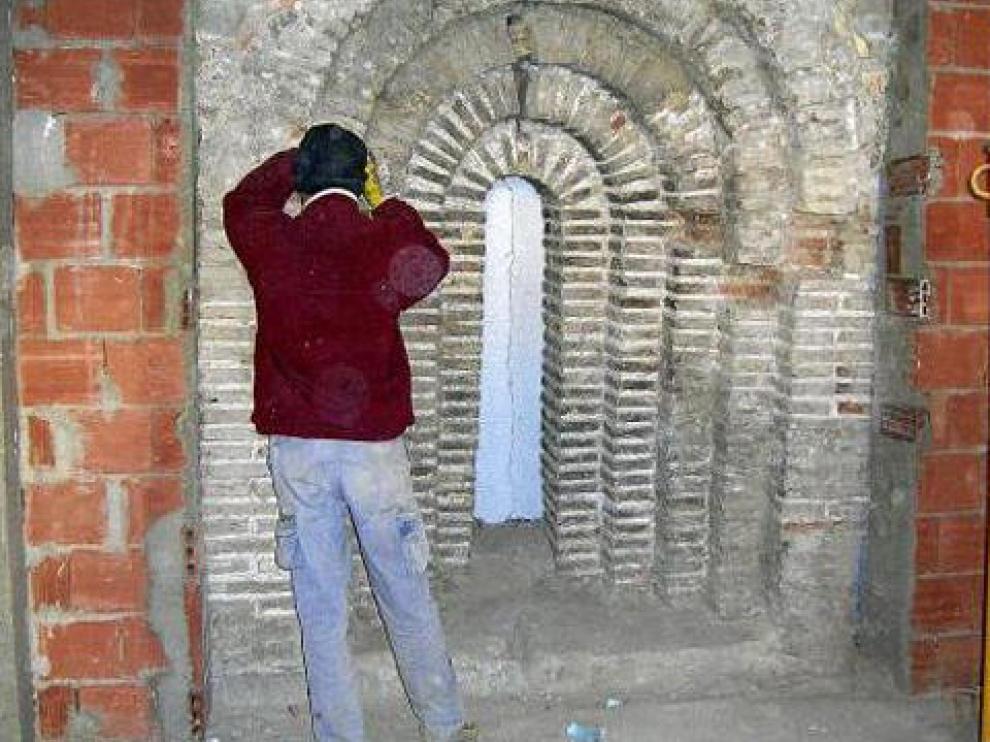 Un obrero trabaja en la rehabilitación del arco aparecido en la que será la casa del párroco