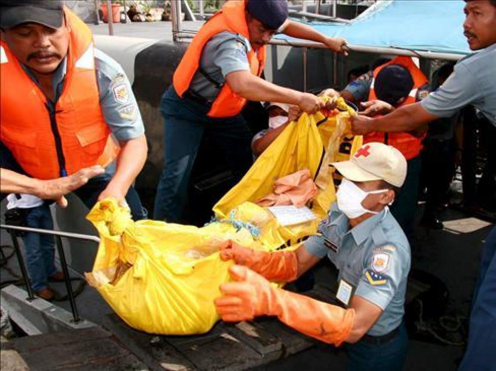 Efectivos de rescate transportan un cadáver en el puerto indonesio de Surabaya.