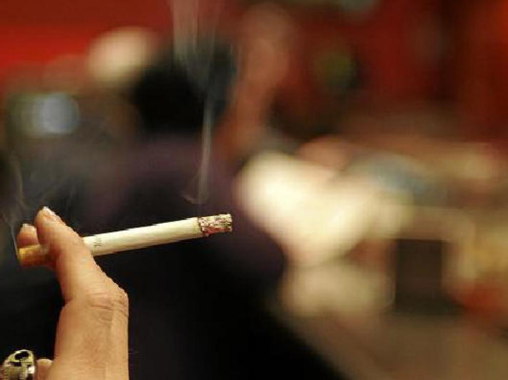 Una mujer sostiene un cigarrillo en un bar de Huesca.