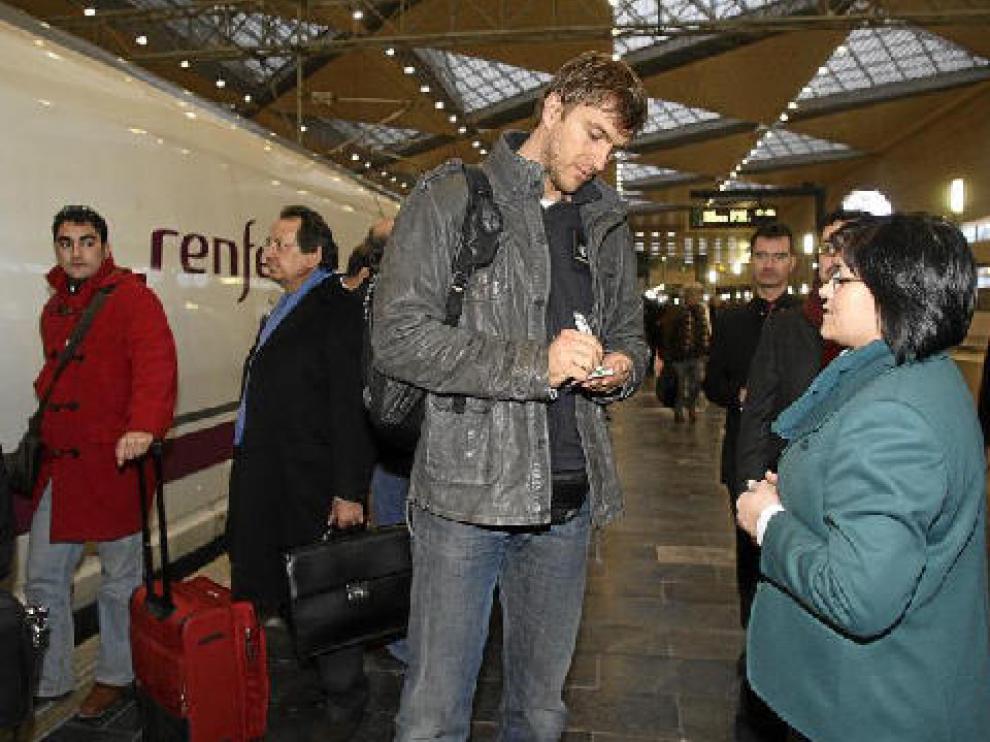 Zizic firma un autógrafo a una empleada de la estación de Delicias a su llegada a Zaragoza.