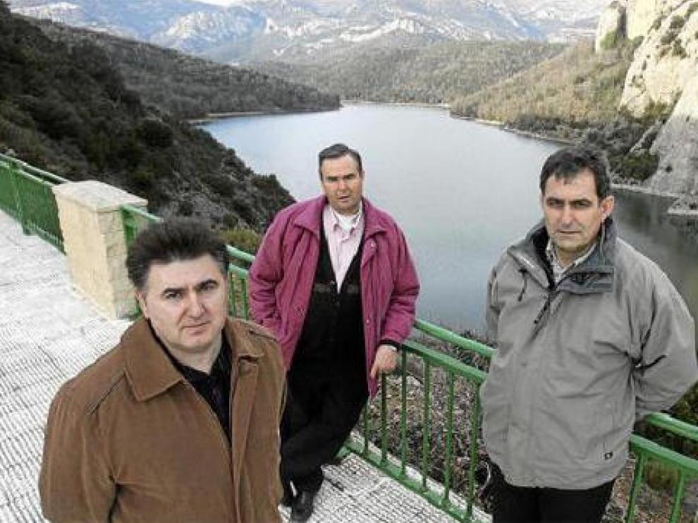 El edil de Aguas, Francisco Sanz (izquierda) con sus antecesores y agricultores expectantes José Antonio Viñuales (centro) y Jose María Oliván, en la presa de Calcón