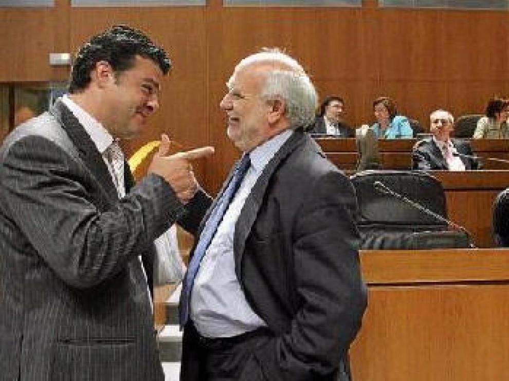 Javier Allué (izquierda) departe con Jesús Miguel Franco durante un pleno de las Cortes