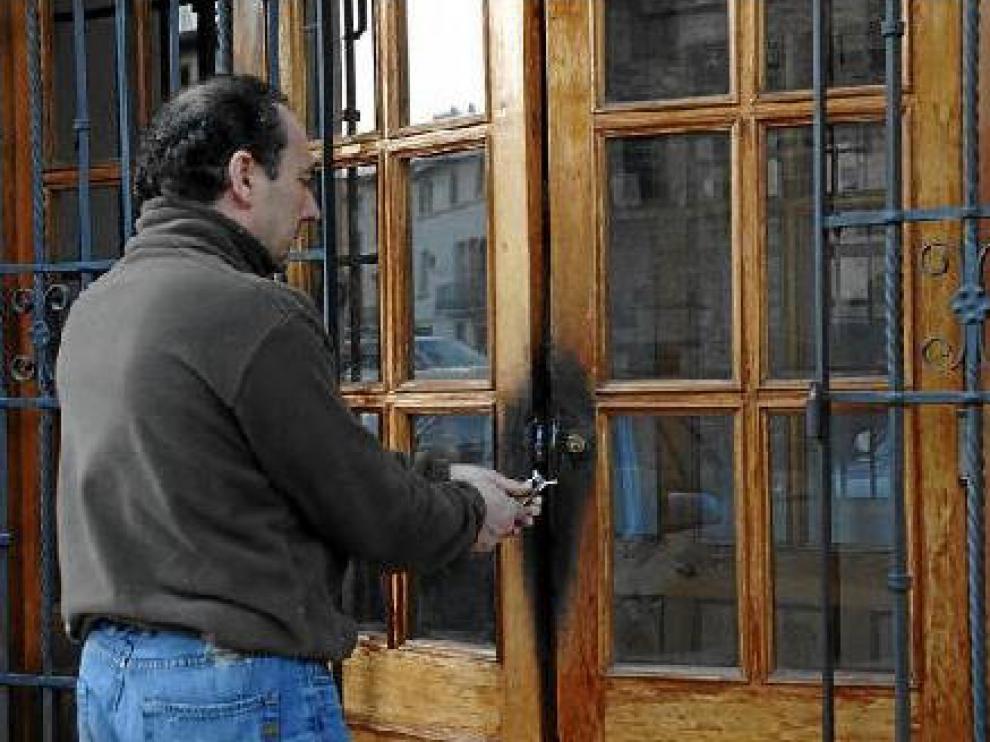 Un hostelero de Rubielos muestra los daños que hicieron los ladrones, que quemaron la puerta.
