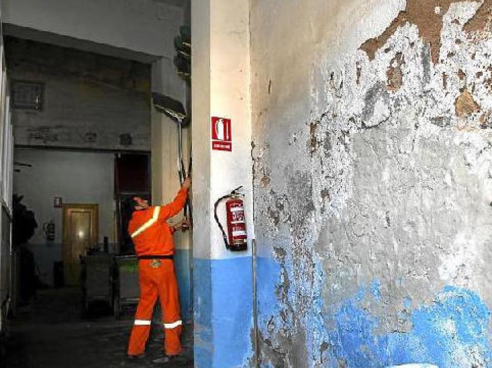 Las paredes del local destinado a los servicios de limpieza del ayuntamento están cubiertas de desconchones y humedades.