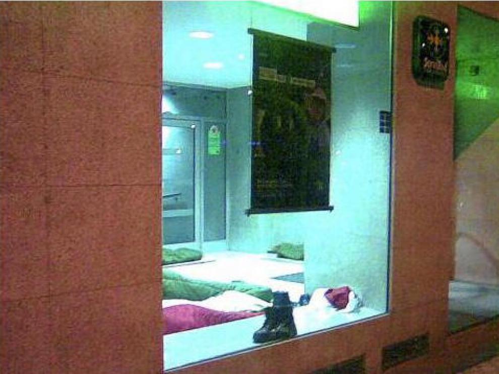 Indigentes durmiendo en un cajero.