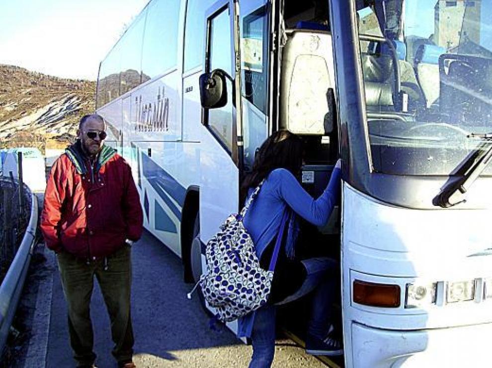 Una chica sube al autobús escolar en la parada de Larrés.