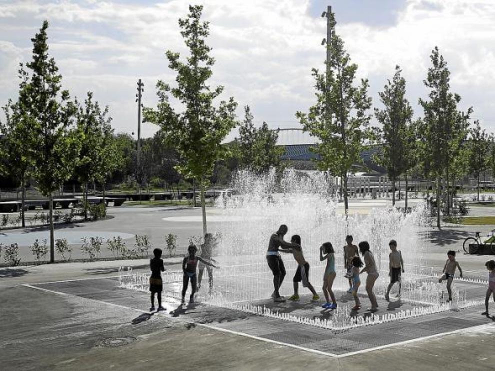 Un grupo de zaragozanos combatía ayer las altas temperaturas en una fuente del frente fluvial, la más popular durante la Expo 2008