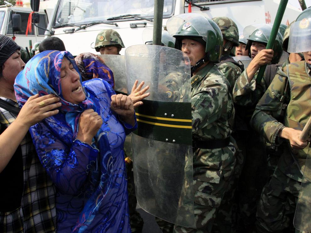 Una mujer se enfrenta a varios agentes de la policía china