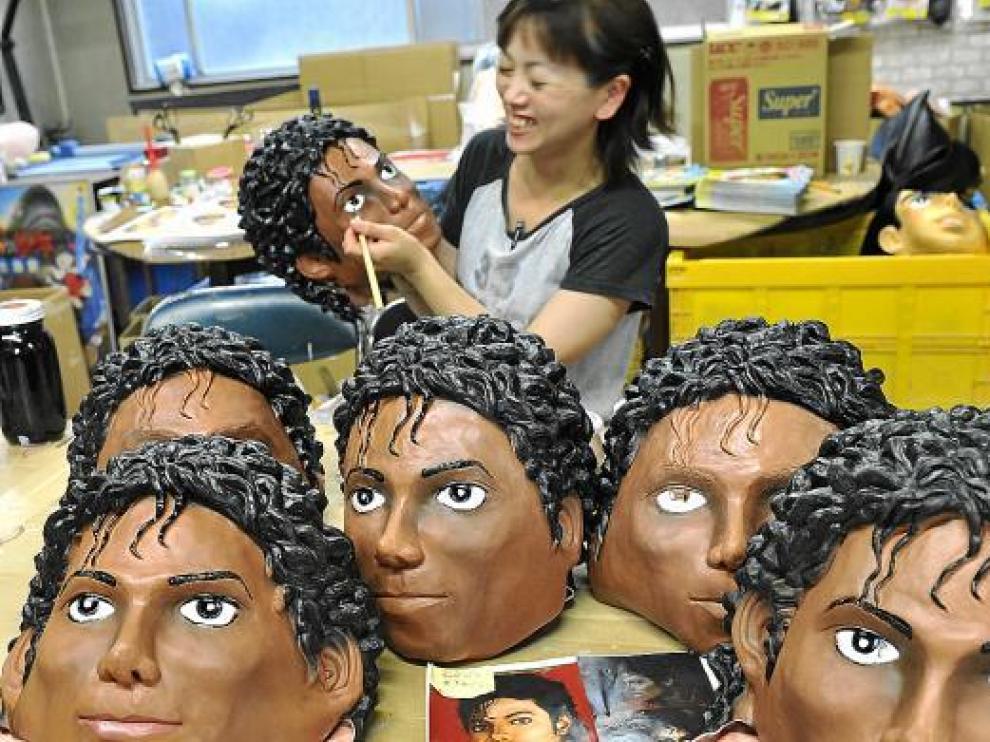 Una artesana japonesa decora unas caretas de goma con la efigie de Michael Jackson.