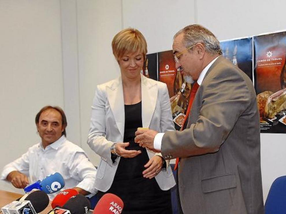 Enrique Bayona, el presidente anterior, entrega la Insignia del Jamón de Teruel a Pilar Martín.