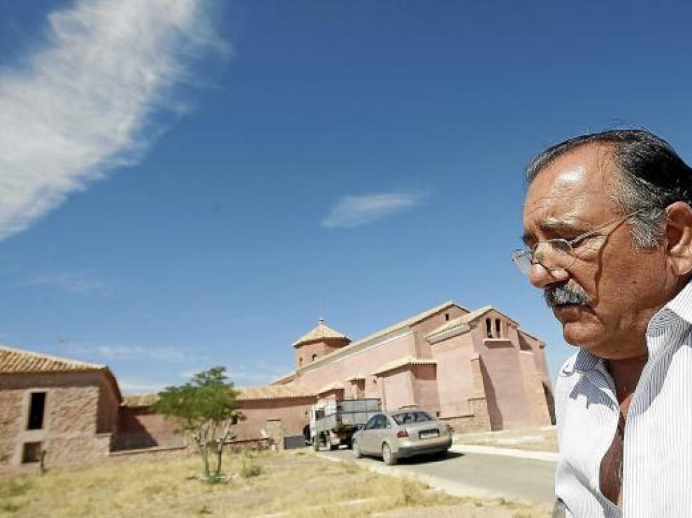 El alcalde de Plenas, Baltasar Yus, frente al albergue y la ermita de El Carrascal.