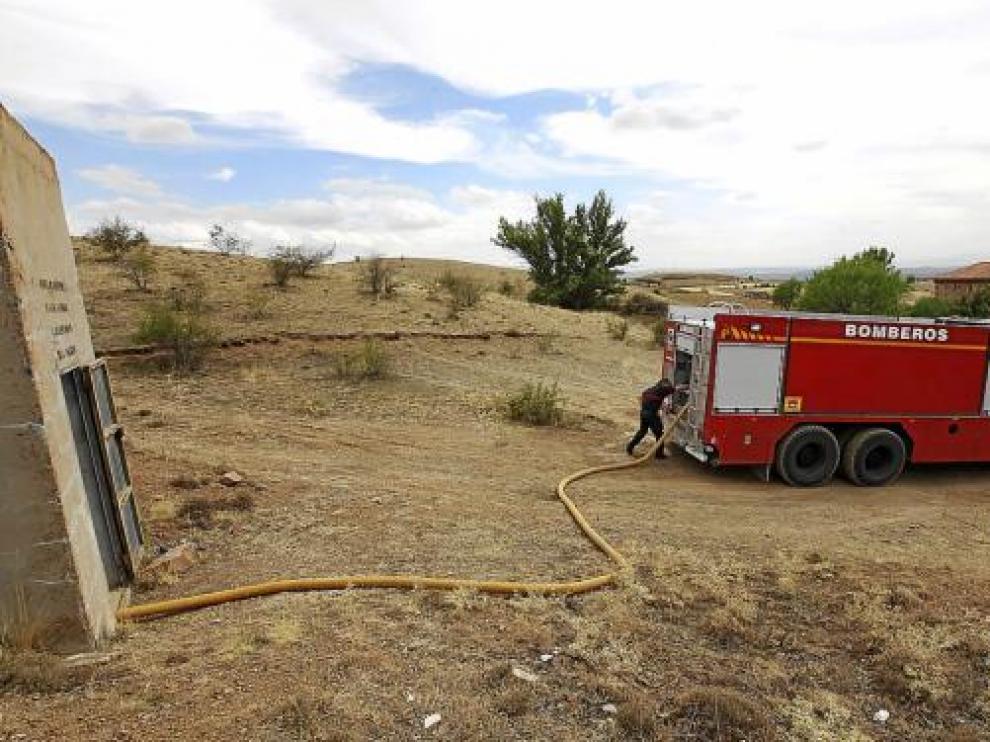 Los bomberos almacenan el agua en el depósito de Collados, barrio de Calamocha.