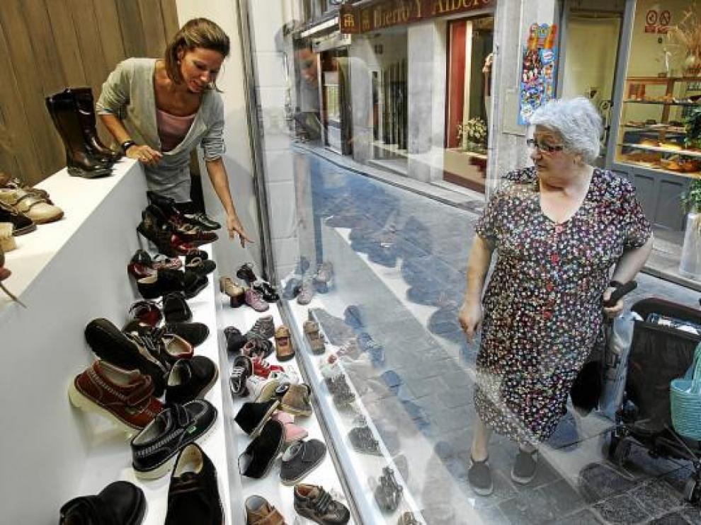 Ainhoa Labadía arregla el escaparate de su zapatería infantil, ayer, en la calle de Ramiro El Monje.