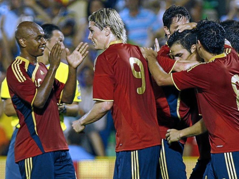 Cesc recibe la felicitación de sus compañeros, tras lograr el primer gol para España, ayer, en Mérida.