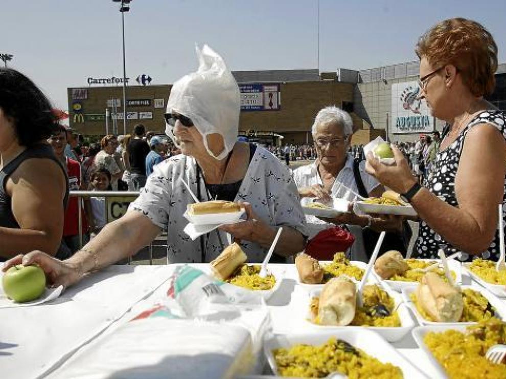 Varias señoras mientras recogían sus raciones de paella ayer al mediodía.