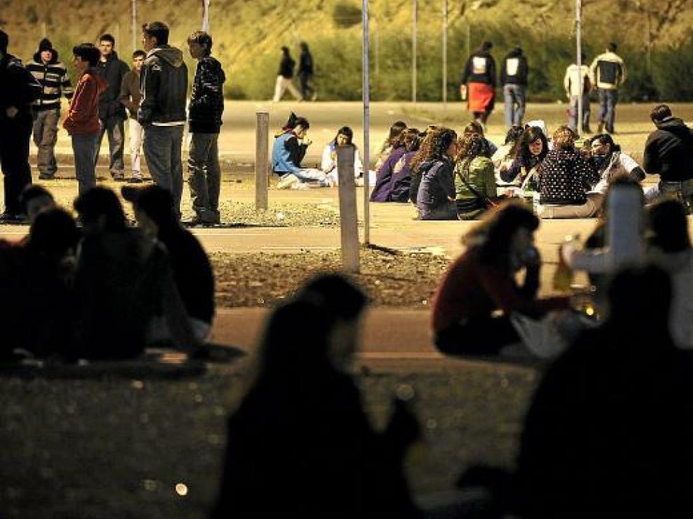 Unos jóvenes, en el botellón que se organiza durante el Pilar en las puertas del recinto de Interpeñas.