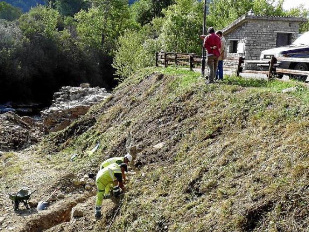 Dos obreros trabajando en una parte del puente, y al fondo el otro extremo de la estructura.