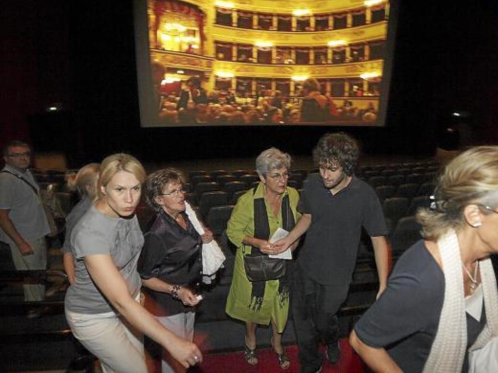 Varias personas buscando ayer asiento en los Cinesa Grancasa, con La Scala proyectada al fondo.