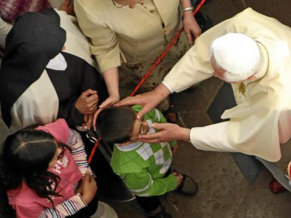Benedicto XVI santigua a un niño en la iglesia de Nuestra Señora de la Victoria de Praga.