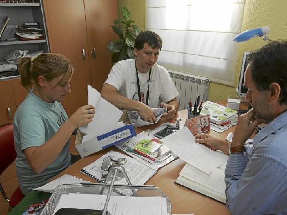 Jesús Callén, director del Pío XII, y los docentes Javier Zamora y Alejandra Guillén miran las encuestas.