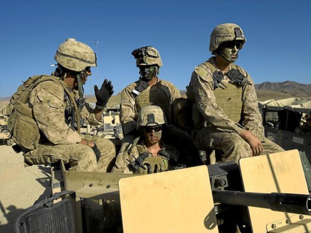 Marines estadounidenses, con pintura de camuflaje en sus caras, se preparan para salir de su base en Farah, ayer en Afganistán.