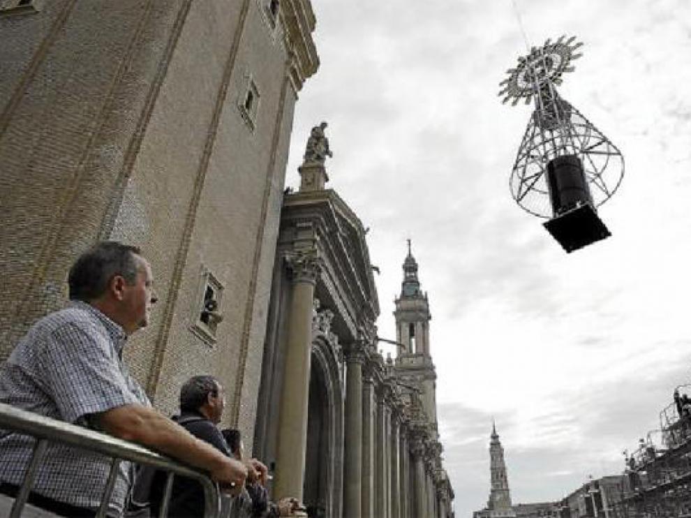 Varios espectadores observan el momento en el que la Virgen se alza hacia el pedestal de hierro. J. M. MarcoVarios espectadores observan el momento en el que la Virgen se alza hacia el pedestal de hierro.