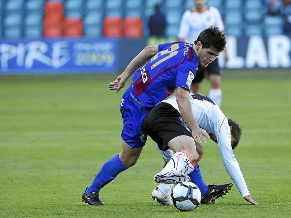 El jugador del Huesca Echaide trata de arrebatarle el balón a un rival, en el choque disputado ayer en el Helmántico
