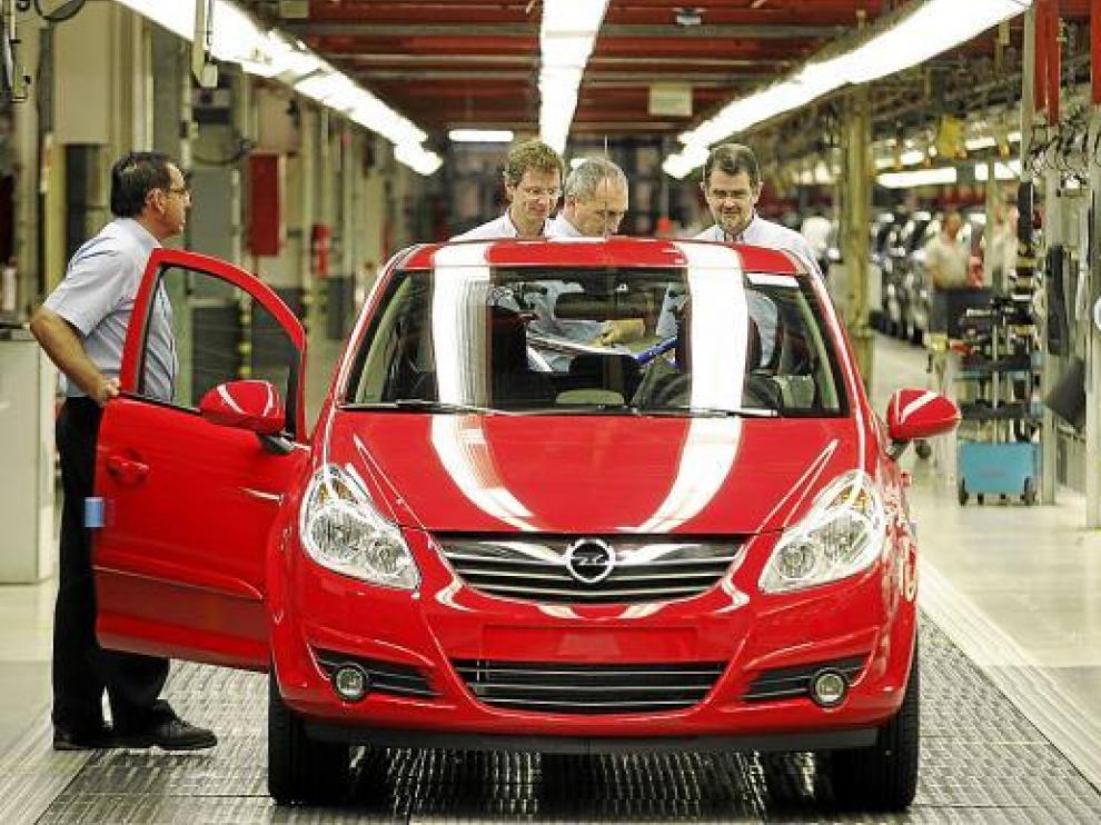 Operarios de la fábrica de Opel en Figueruelas comprueban uno de los vehículos de cadena.