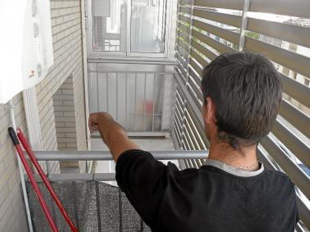 Uno de los vecinos señala la ventana desde la que saltaron.