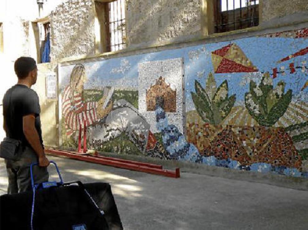 Un vecino contempla el mural de Ignacio Fortún, situado en un edificio abandonado.