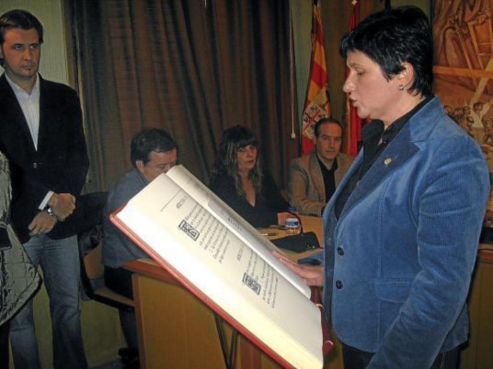 La socialista Vicente jurando su cargo como alcaldesa de Alcorisa ante la mirada de Burriel, al fondo.