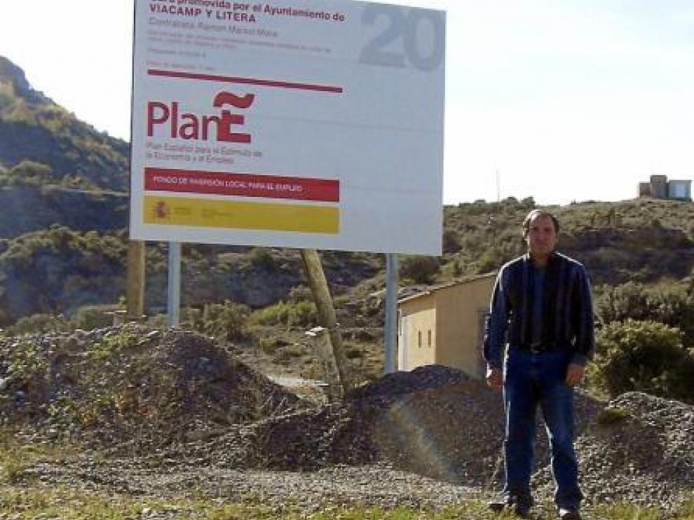 Alfredo Pociello, alcalde de Viacamp y Litera, con el cartel del Plan E, situado a la entrada del pueblo.