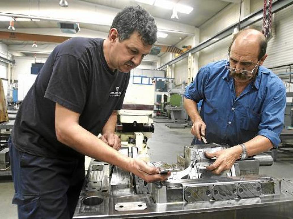Dos operarios ultiman una de las piezas que fabrica Moldes J. Cereza en el polígono de Malpica.