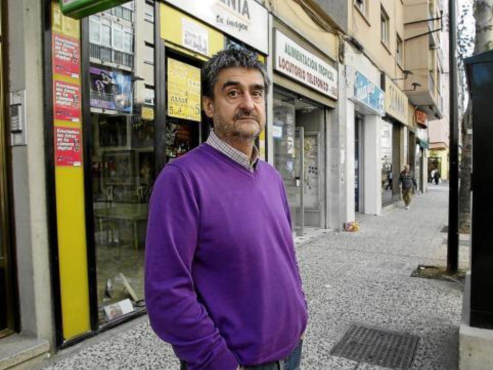 Alfonso Bernalte, junto a uno de los dos armarios que tapan la fachada de su tienda, Fotogenia.