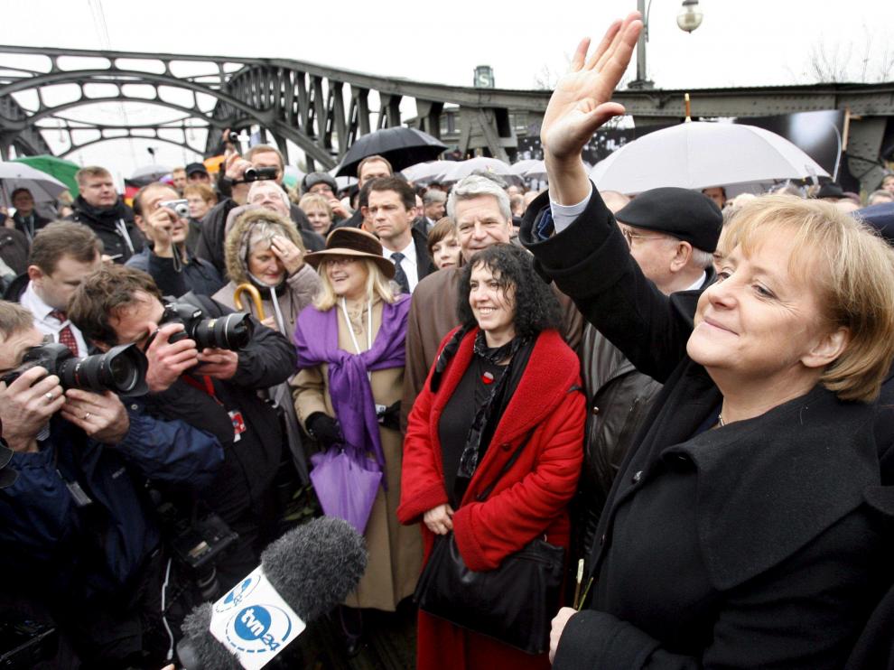 Merkel saluda a la multitud mientras cruza simbólicamente el antiguo paso de la calle Bornholm en Berlín.