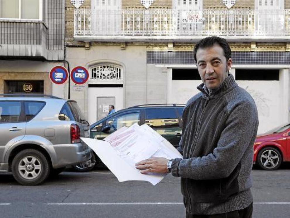 Sergio García, con sus multas, ante una zona de carga y descarga ocupada por turismos en el Coso.