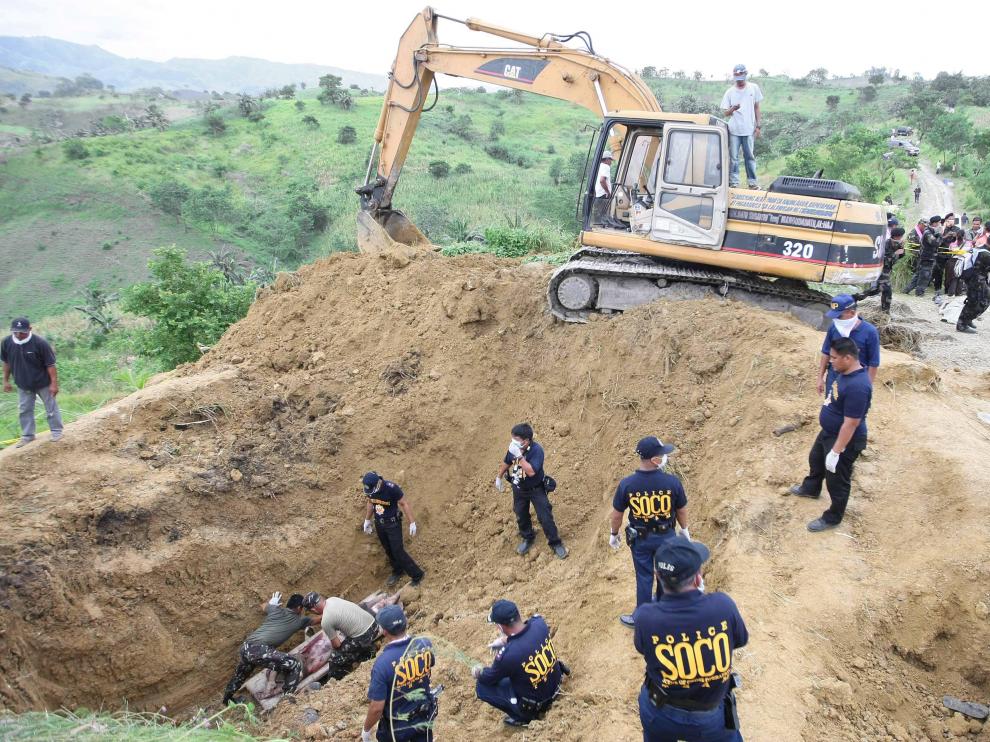 Varios policías recuperan los cuerpos de una de las fosas encontradas