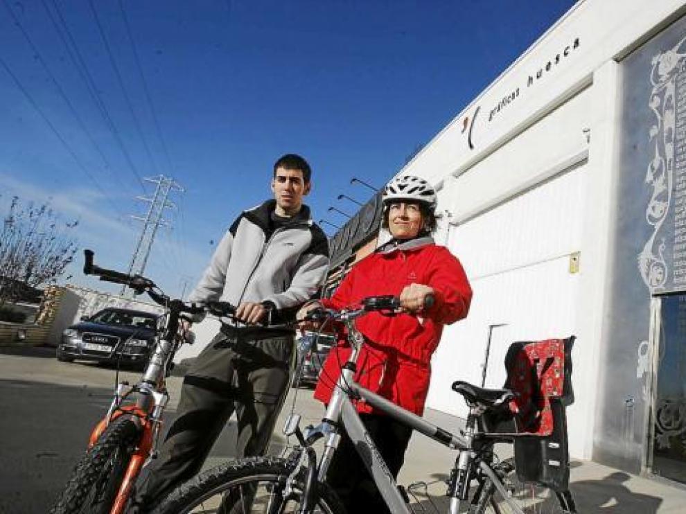 Adrián Inglada y Silvia Perbech, con sus bicicletas delante de la empresa Gráficas Huesca