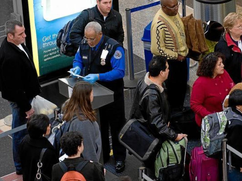 Un agente identifica a los pasajeros, ayer, en el aeropuerto Ronald Reagan de Washington.