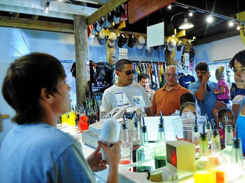 Barack Obama (centro) y su hija Malia (derecha) en una visita a la tienda de helados 'Island Snow' en Kailua, Hawaii, el viernes 1 de enero. El presidente descansa con su familia desde el pasado 24 de diciembre en su isla natal.