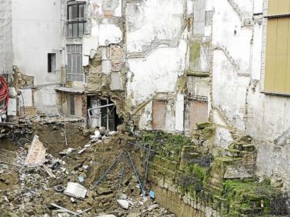Un bombero ayuda a un residente del número 31 del Coso Bajo a sacar ropa de su vivienda