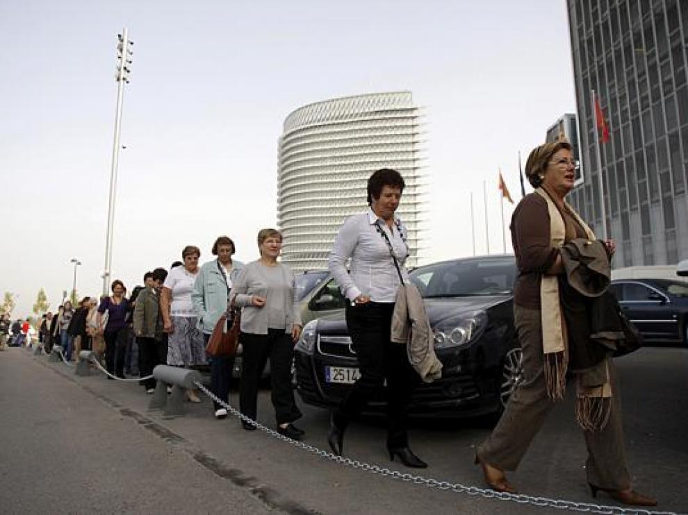 Asistentes a uno de los congresos sortean los coches que habían tomado el acceso al edificio