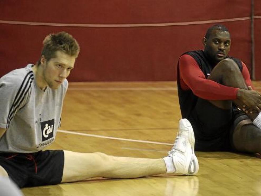 Darren Phillip y David Barlow realizan estiramientos durante un entrenamiento.