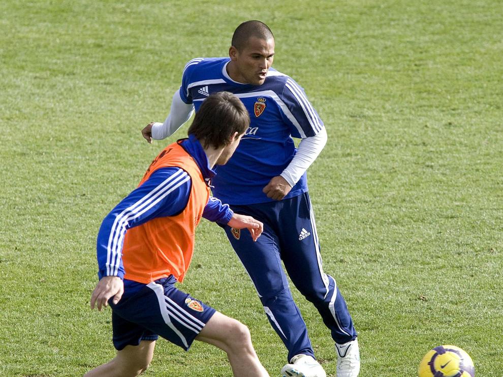 Suazo golpea el balón durante el entrenamiento ante la presión de Goni.