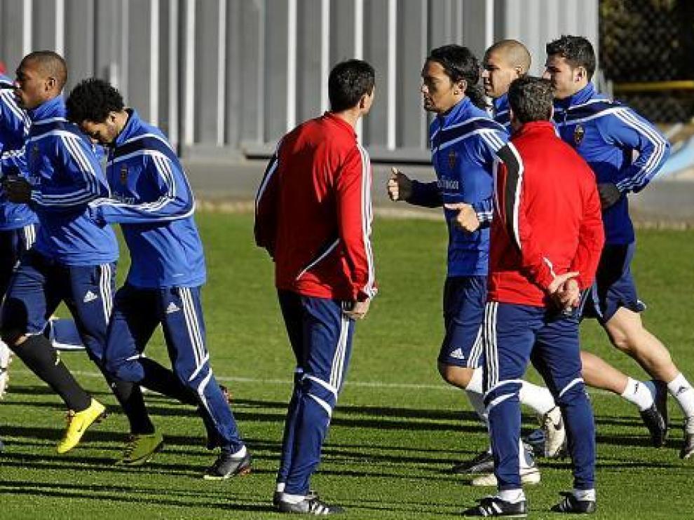 Gay y Nayim, de espaldas, observan a sus jugadores en un entrenamiento.