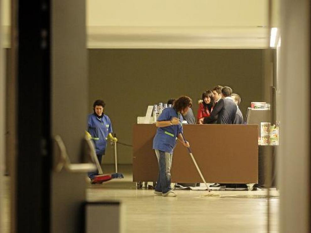 Personal de limpieza contratado para un espectáculo limpia un charco en el Palacio de Congresos.