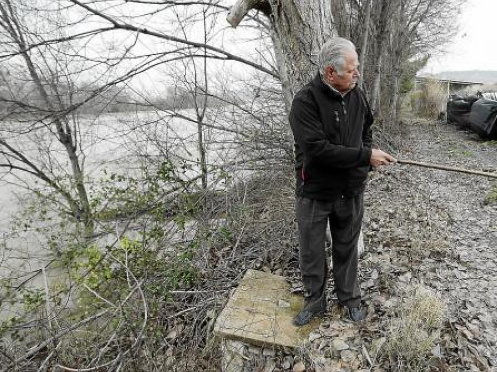 Enrique Rubio, vecino de Osera de Ebro, observa la distancia entre el río y su huerto.