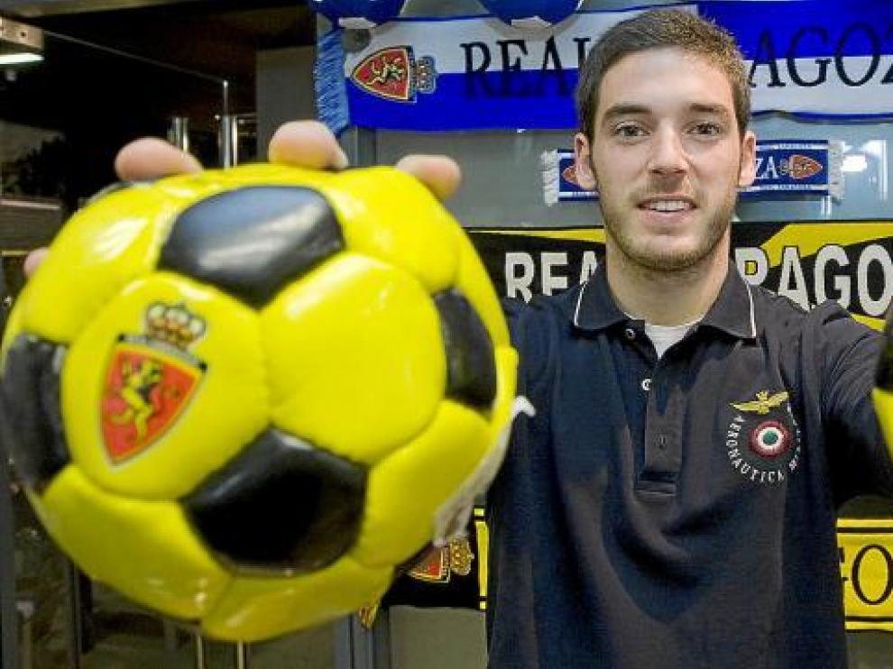 Pablo Alcolea suejeta dos miniaturas de balón en la tienda del Real Zaragoza.